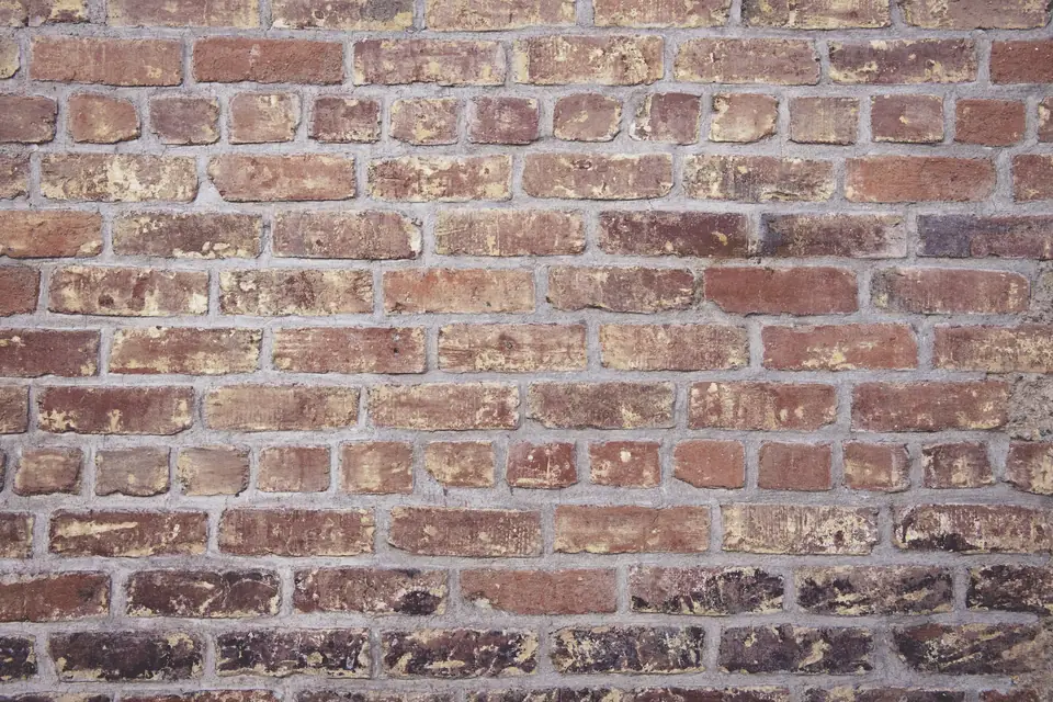 Mur de briques anciennes rouges et rosées, joints usés
