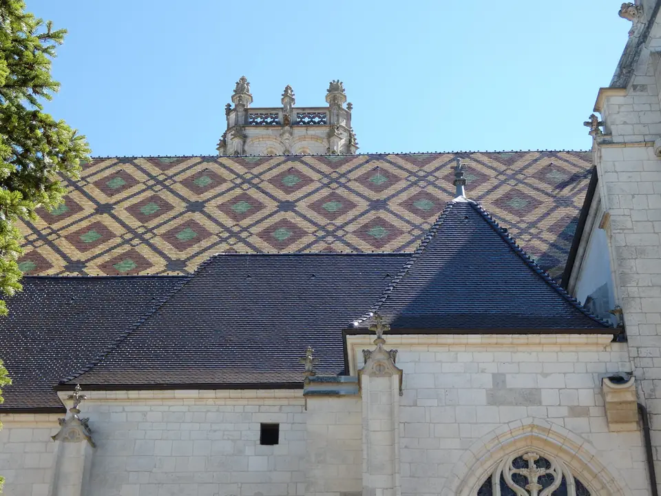 Façade nord de l’église de Brou : grand pan de tuiles vernissées en losanges au-dessus de la pierre blanche