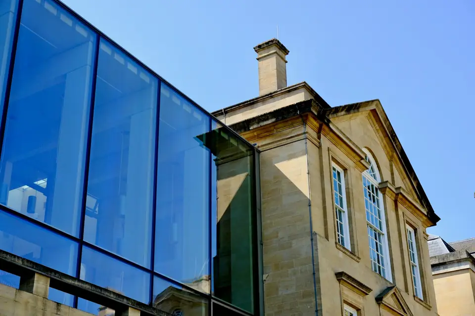 Volume vitré contemporain accolé à une bâtisse ancienne en pierre