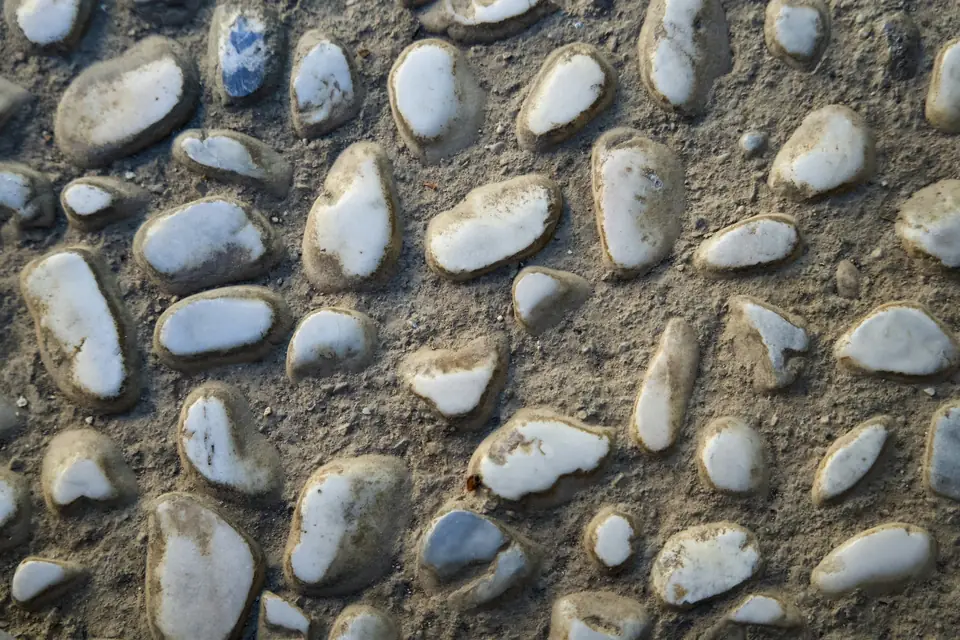 Galets blancs pris dans un liant minéral, surface de sol en relief