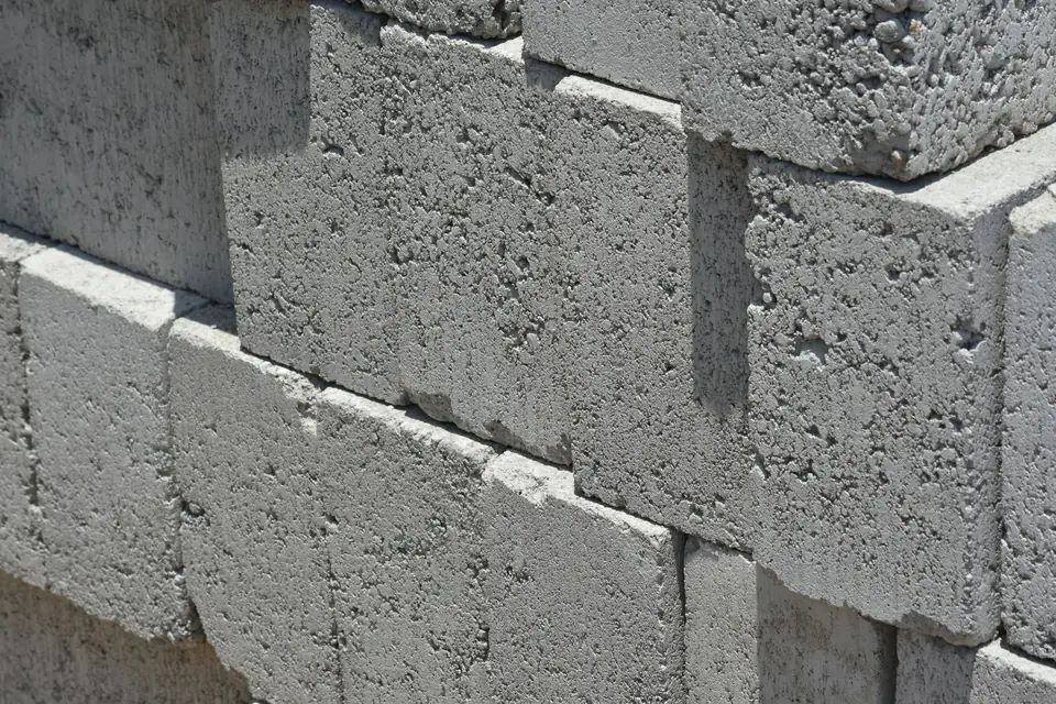 Mur de blocs béton gris montés à joints décalés, vu de près