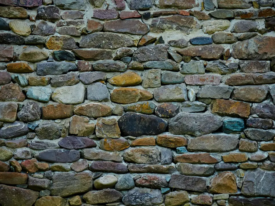 Mur de pierres de toutes nuances, joints clairs, sans enduit