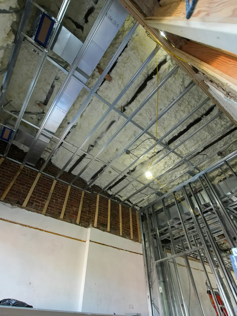 Pièce en travaux : ossature métallique et plafond garni d’isolant